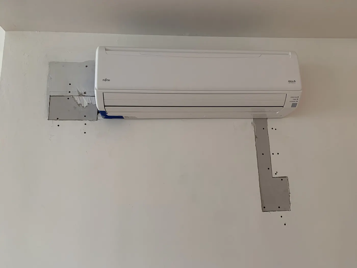 Drywall patch installed before joint compound around mini-split unit
