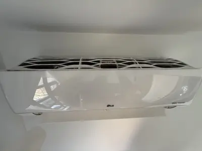 LG dual inverter mini-split AC unit professionally installed on white wall in NYC apartment