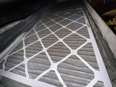 Heavily clogged dirty AC air filter removed during HVAC maintenance inspection in NYC