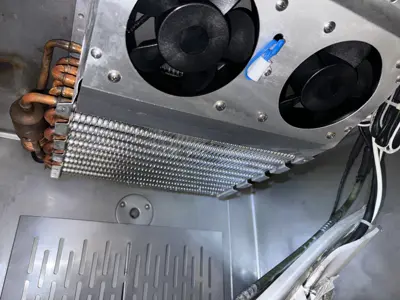 Clean refrigerator or commercial AC evaporator coil with copper lines and dual fans after servicing in NYC