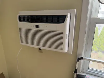 Frigidaire window AC unit professionally installed in NYC apartment wall sleeve