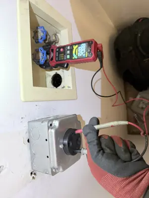 Electrician testing wiring with multimeter during outlet installation and electrical box work in NYC
