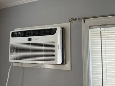 Wall-mounted window AC unit installed in NYC apartment bedroom by Repair ASAP LLC