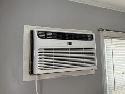 Frigidaire window AC unit professionally installed in a NYC apartment wall opening