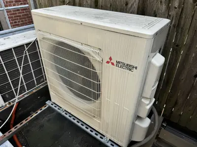 Mitsubishi Electric mini-split outdoor condenser unit installed on rooftop pad in NYC