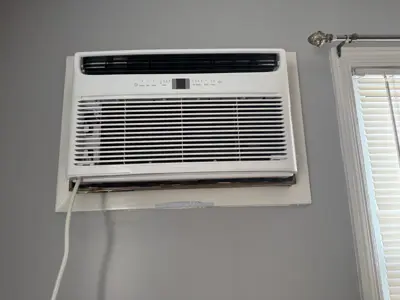 Frigidaire window AC unit professionally installed in NYC apartment with clean wall finish
