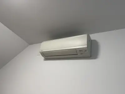 Daikin mini-split AC unit mounted on white wall after professional installation in NYC home