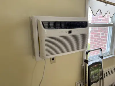 Frigidaire window AC unit professionally installed through wall in NYC home with clean finish