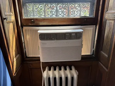 Frigidaire window AC unit professionally installed in a classic NYC apartment