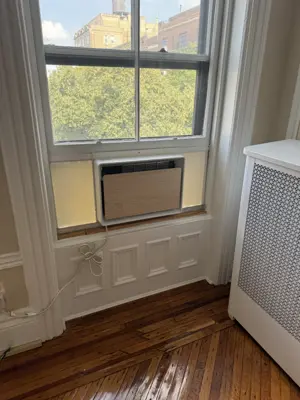 AC installation in progress — bracket bolted to window sill