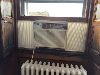 GE window AC unit installed in NYC apartment with wood panel trim