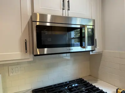 Microwave or range hood installation above stove