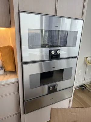 Stainless steel Gaggenau double wall oven installed in modern NYC kitchen cabinetry