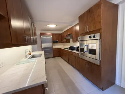 Fully equipped NYC kitchen with installed stainless steel fridge, double wall oven, and microwave