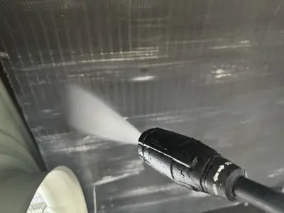 Pressure washing condenser coils of a commercial appliance unit during professional cleaning service