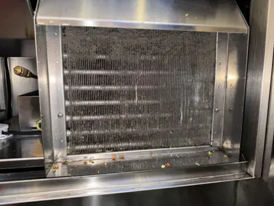Dirty clogged condenser coils on a commercial or residential appliance unit before professional cleaning service