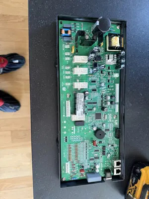 Appliance control board being installed into housing unit during repair service by Repair ASAP LLC