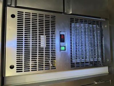 Commercial refrigerator control panel showing active green indicator light after successful repair in NYC