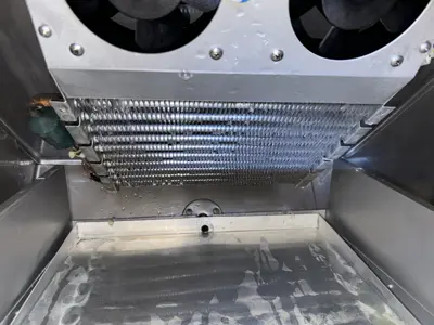 Interior evaporator coils and condenser fans of a commercial refrigeration unit during service