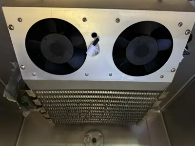 Cleaned dual evaporator fans and coil assembly inside commercial refrigeration unit after professional servicing