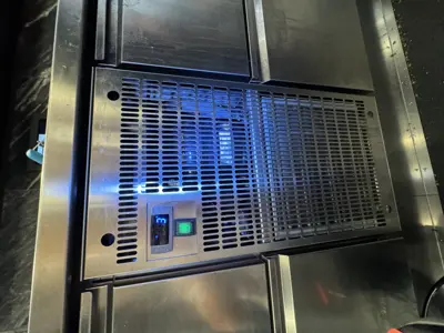 Commercial stainless steel appliance with illuminated blue indicator light after servicing in NYC