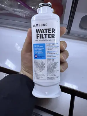 Samsung refrigerator water filter replacement being held during appliance service call in NYC