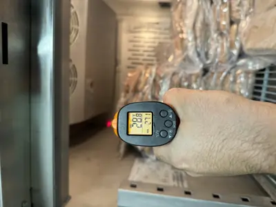 Infrared thermometer reading 28°F inside a commercial refrigeration unit after repair by Repair ASAP LLC