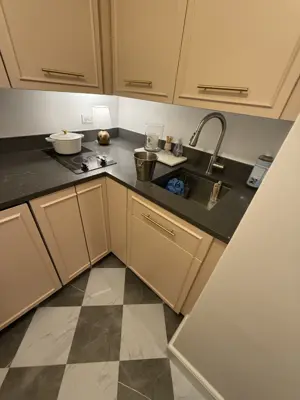 Modern NYC kitchen with installed induction cooktop, sink faucet, and custom cabinetry after handyman service