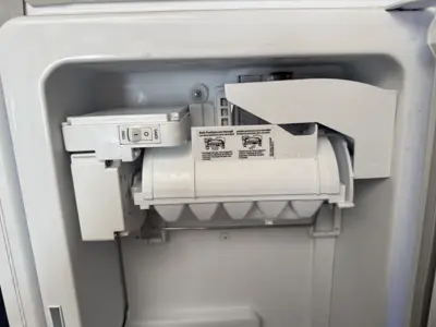 Close-up of refrigerator ice maker unit during appliance repair service in NYC
