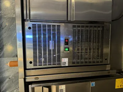 Commercial refrigeration unit installed and operational with green indicator light in NYC kitchen