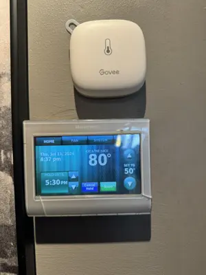 Honeywell smart thermostat and Govee temperature sensor installed on wall in NYC home
