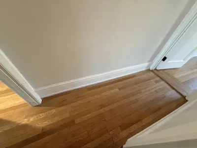 Baseboard installation along newly finished floor