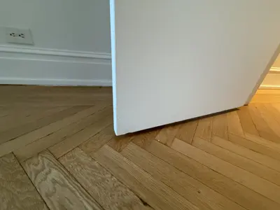 Baseboard installation along newly finished floor