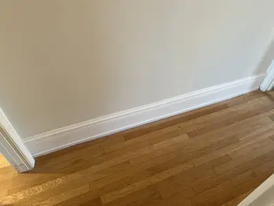 Baseboard installation along newly finished floor