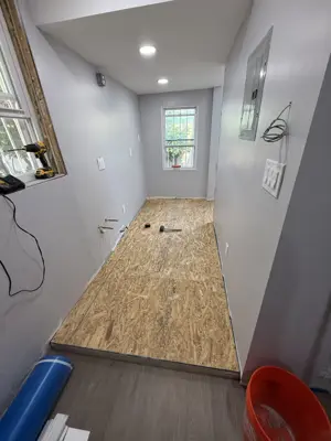 OSB subfloor boards being installed in hallway for flooring preparation