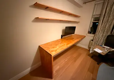 Floating wood desk and matching wall shelves assembled and mounted in NYC home office