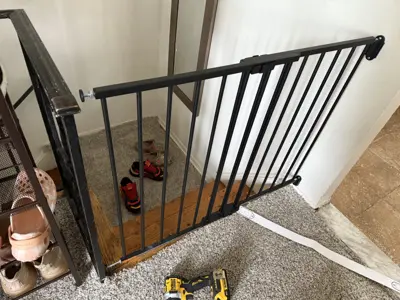 Installed black metal safety gate at top of staircase in NYC home
