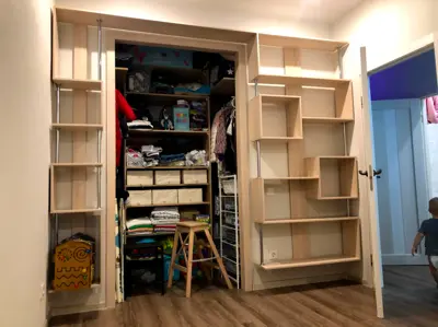 Completed custom closet shelving system with wooden shelves and organized storage installed in NYC apartment