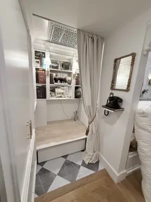 elegantly assembled built-in shelving unit with curtain and checkerboard tile floor in nyc home
