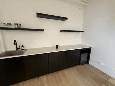 completed modern black kitchen cabinet and floating shelf assembly in a nyc office or apartment