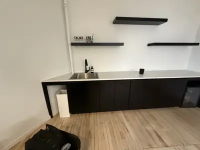 completed modern black kitchen cabinet and floating shelf installation with marble countertop in nyc