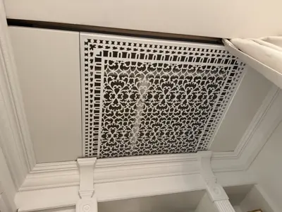 Decorative ventilation screen installed flush with coffered ceiling
