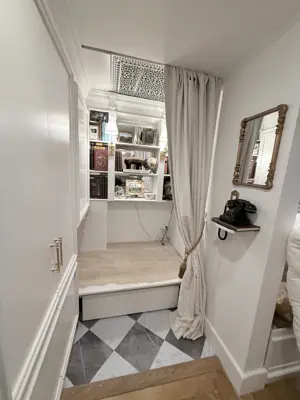 elegantly decorated nyc hallway with curtain rod installation and decorative shelving completed