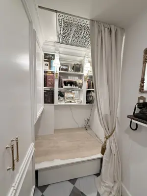 elegant reading nook with built-in shelving, curtains, and decorative ceiling vent installed in nyc home