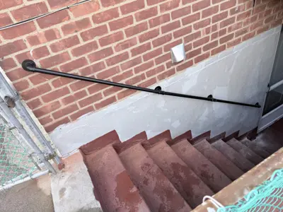 newly installed black metal handrail along outdoor brick staircase in nyc