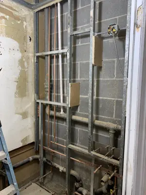 rough-in plumbing with copper pipes and metal framing exposed during nyc bathroom renovation