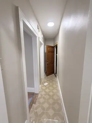 freshly installed patterned tile flooring in a nyc apartment hallway with painted white walls