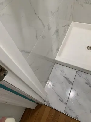 completed marble tile shower installation with white shower base and tiled walls in nyc bathroom