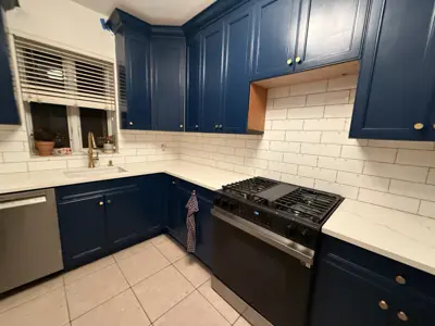 freshly painted navy blue kitchen cabinets with white subway tile backsplash and stainless appliances in nyc