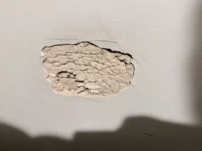 Damaged ceiling with cracked and peeling plaster before drywall repair in NYC home